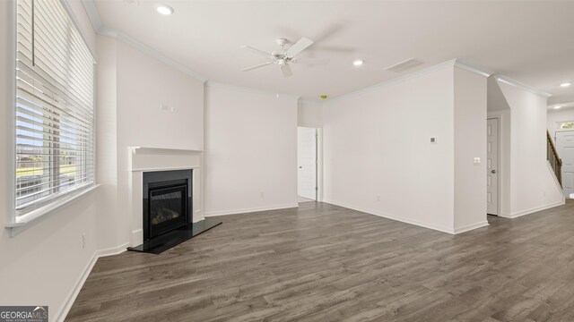 unfurnished living room featuring dark hardwood / wood-style floors, ceiling fan, and ornamental molding
