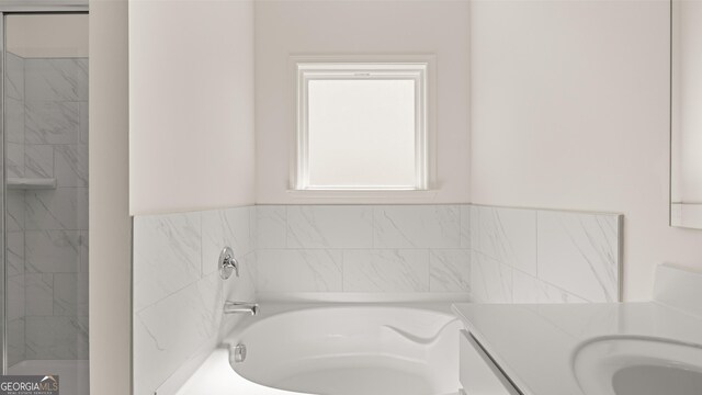 bathroom with vanity and a bath