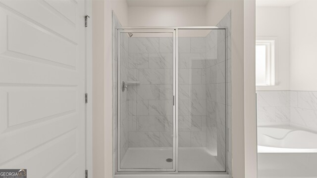 bathroom featuring independent shower and bath