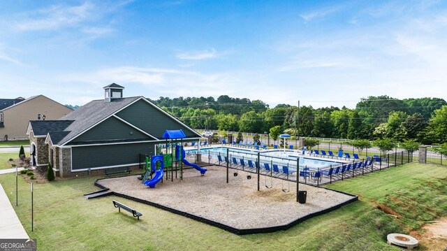 view of jungle gym featuring a lawn and a community pool