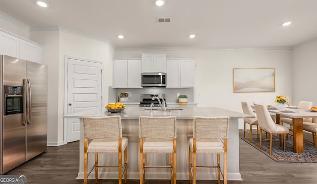 kitchen with a kitchen island with sink, sink, white cabinets, and appliances with stainless steel finishes