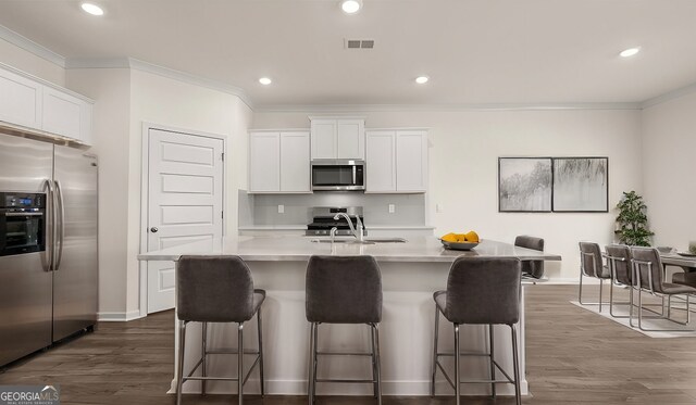 kitchen featuring a center island with sink, white cabinets, and stainless steel appliances
