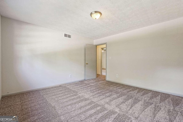 carpeted spare room with a textured ceiling