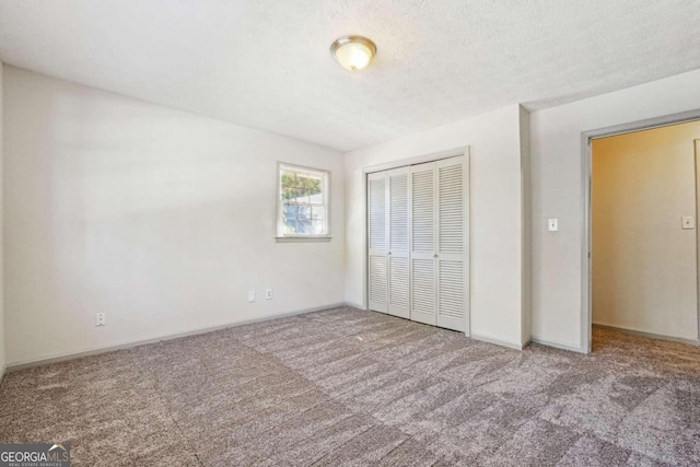 unfurnished bedroom featuring a closet, carpet flooring, and a textured ceiling