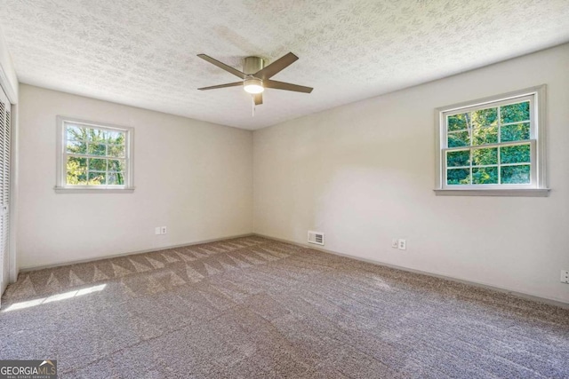 carpeted empty room with a textured ceiling and ceiling fan