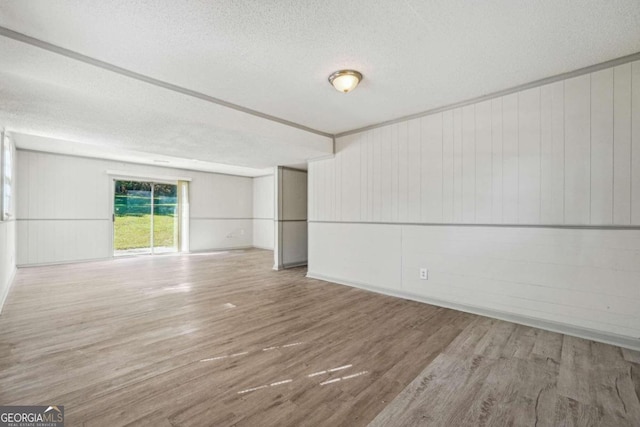 spare room with a textured ceiling and hardwood / wood-style flooring