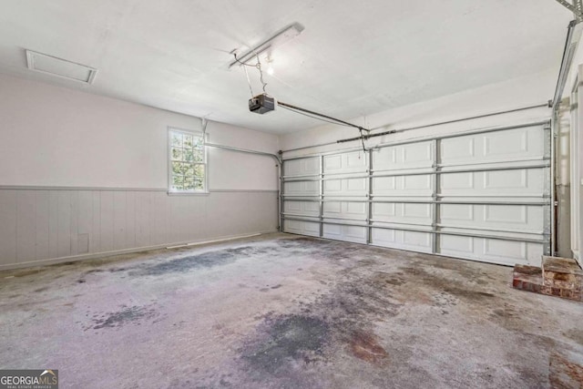 garage featuring a garage door opener and wood walls