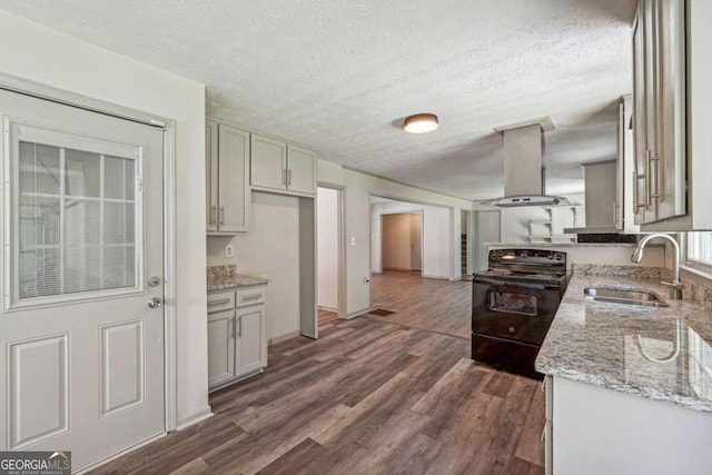 kitchen featuring island exhaust hood, dark wood-type flooring, sink, black / electric stove, and light stone counters