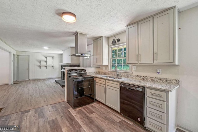 kitchen featuring black appliances, sink, a textured ceiling, hardwood / wood-style floors, and wall chimney exhaust hood