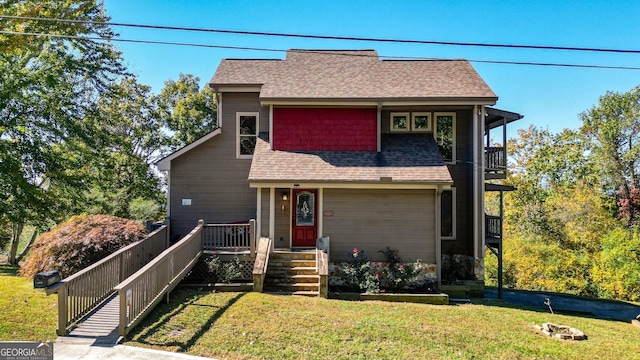 view of front property featuring a front yard and a balcony