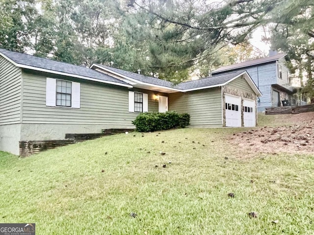 single story home with a garage and a front lawn