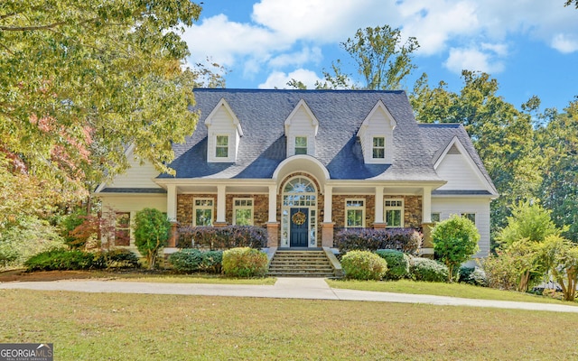 cape cod house featuring a front yard and a porch