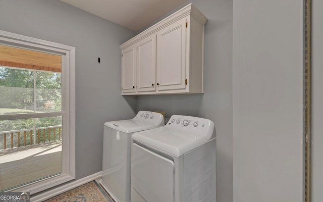 laundry area featuring washer and clothes dryer and cabinets