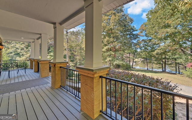 wooden deck featuring covered porch and a water view