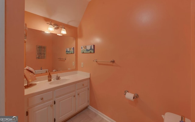 bathroom with vanity, lofted ceiling, and tile patterned flooring