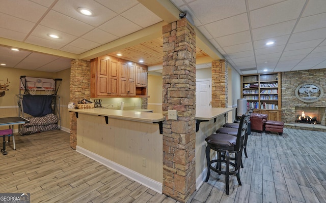 715 Cross Creek Dr, Toccoa, GA 30577 - kitchen featuring decorative columns, light wood finished floors, a kitchen bar, open floor plan, and baseboards