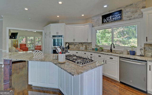 kitchen featuring appliances with stainless steel finishes, white cabinetry, a healthy amount of sunlight, and sink