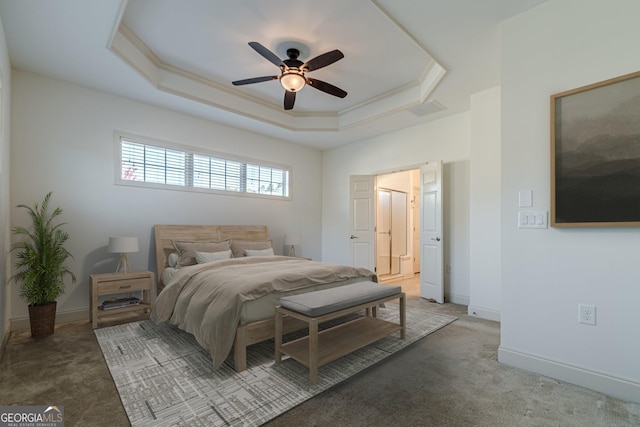 carpeted bedroom with ceiling fan, ornamental molding, and a tray ceiling