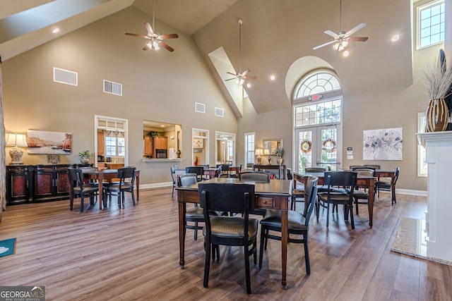 dining room with hardwood / wood-style flooring, a healthy amount of sunlight, ceiling fan, and french doors