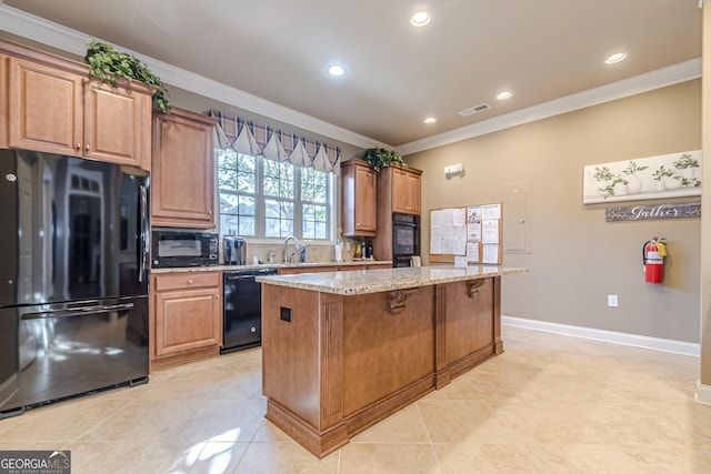 kitchen featuring light stone counters, crown molding, a kitchen island, and black appliances