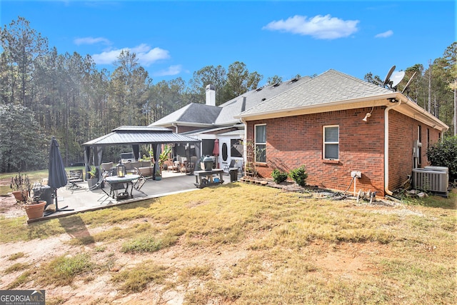 rear view of property featuring a patio, cooling unit, a lawn, and a gazebo