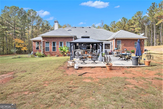 back of property with a patio area, a yard, and a gazebo