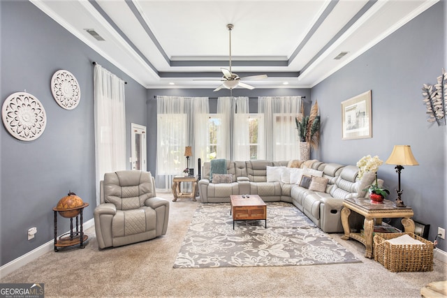 carpeted living room featuring crown molding, ceiling fan, and a raised ceiling