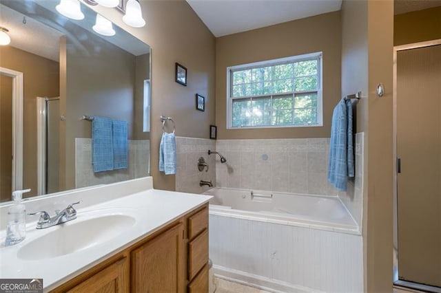 full bathroom featuring vanity, a shower stall, and a bath