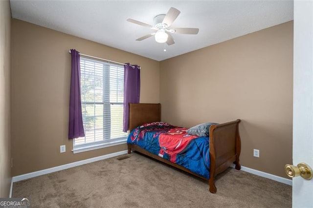 carpeted bedroom featuring ceiling fan and multiple windows