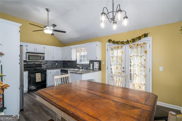 kitchen with appliances with stainless steel finishes, white cabinetry, lofted ceiling, decorative light fixtures, and dark hardwood / wood-style floors