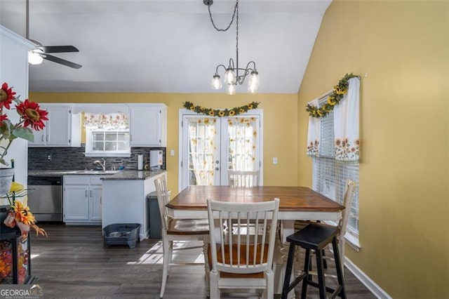 dining area featuring vaulted ceiling, dark wood-type flooring, ceiling fan with notable chandelier, french doors, and sink