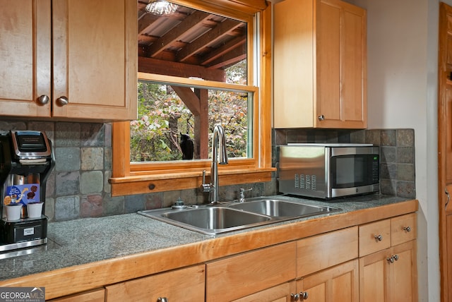 kitchen featuring backsplash, sink, and vaulted ceiling with beams