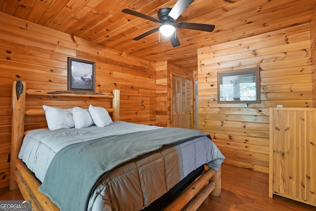 bedroom with a closet, wooden walls, wooden ceiling, hardwood / wood-style floors, and ceiling fan