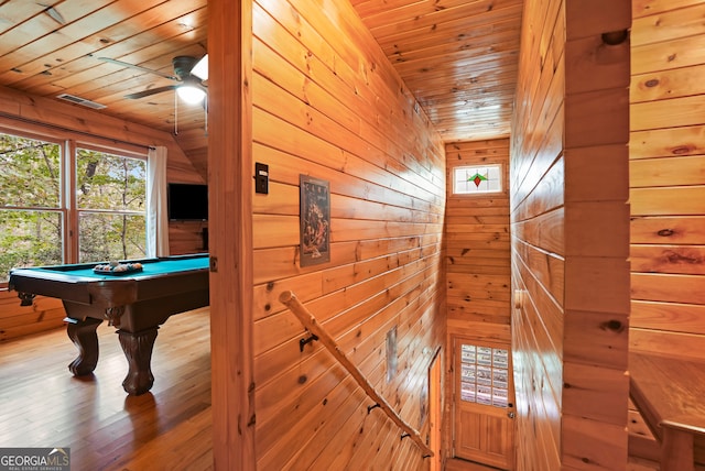 interior space featuring pool table, ceiling fan, wooden ceiling, wood-type flooring, and wooden walls