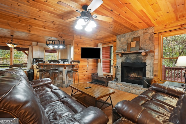 living room with hardwood / wood-style flooring, wood ceiling, wood walls, and a stone fireplace