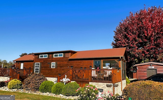 view of front of home with a deck and a storage unit