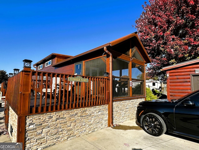 view of home's exterior featuring a wooden deck and a sunroom