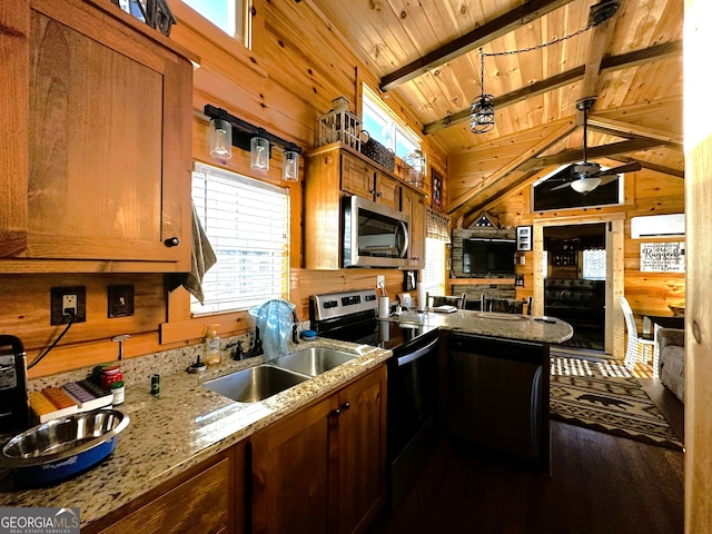 kitchen with sink, vaulted ceiling with beams, wood ceiling, stainless steel appliances, and wooden walls