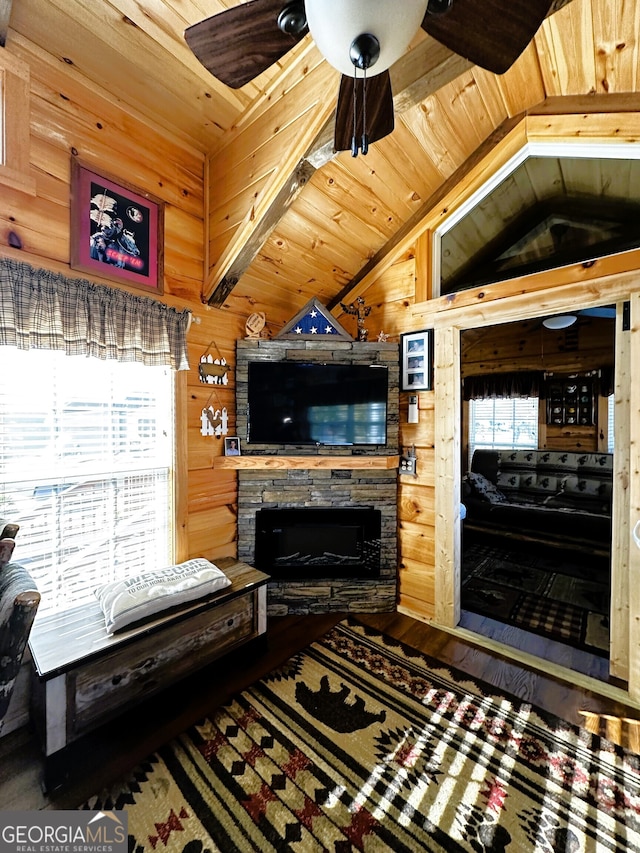 living room with lofted ceiling, wooden ceiling, hardwood / wood-style floors, a fireplace, and wood walls