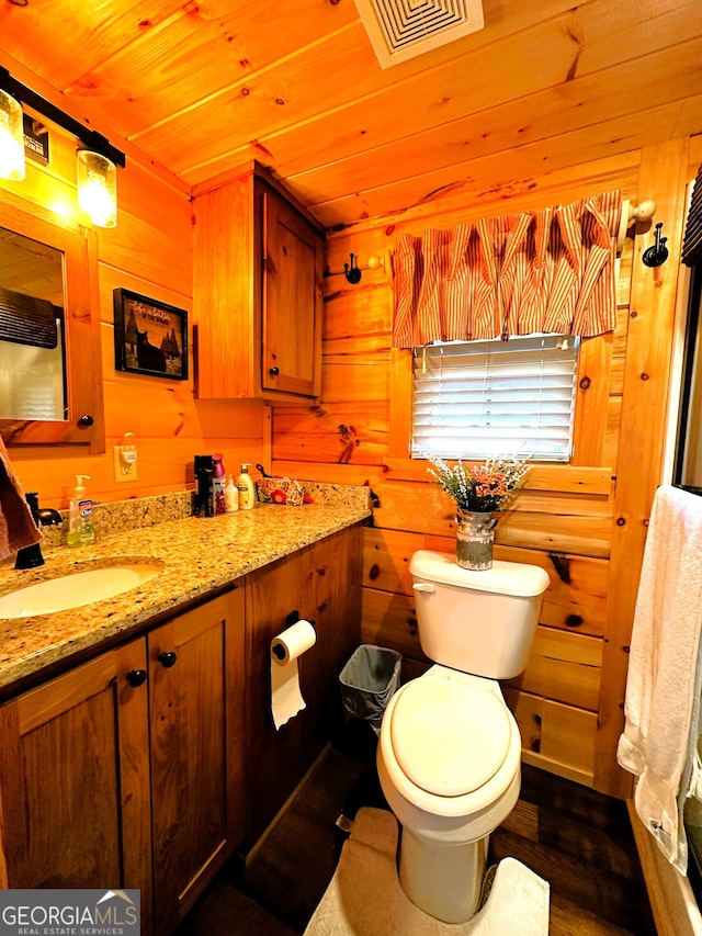 bathroom featuring wood ceiling, hardwood / wood-style floors, toilet, vanity, and wooden walls