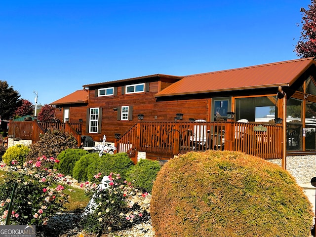 rear view of house featuring a wooden deck