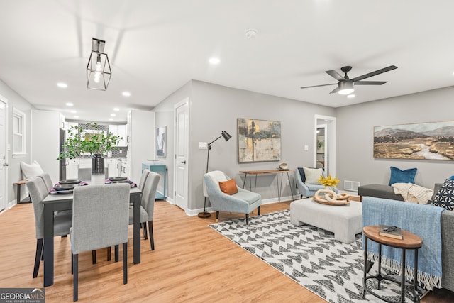 living room with light hardwood / wood-style flooring and ceiling fan