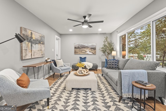 living room with ceiling fan and light hardwood / wood-style flooring