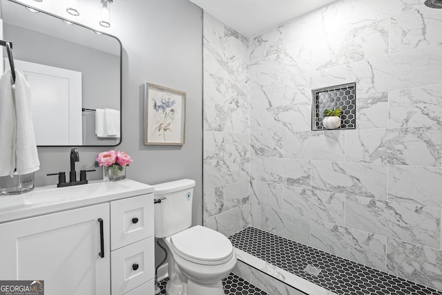 bathroom featuring vanity, toilet, and a tile shower