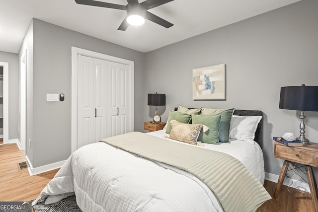 bedroom featuring hardwood / wood-style floors, ceiling fan, and a closet