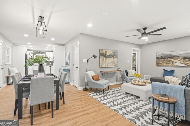 living room with light hardwood / wood-style floors and ceiling fan