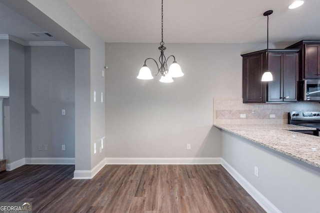 kitchen featuring tasteful backsplash, appliances with stainless steel finishes, light stone countertops, dark hardwood / wood-style floors, and decorative light fixtures