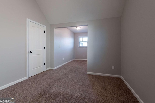 empty room featuring carpet and vaulted ceiling