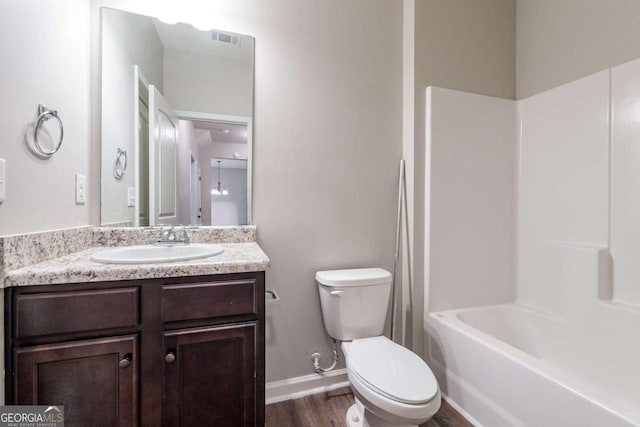 full bathroom with toilet, hardwood / wood-style floors, vanity, and tub / shower combination