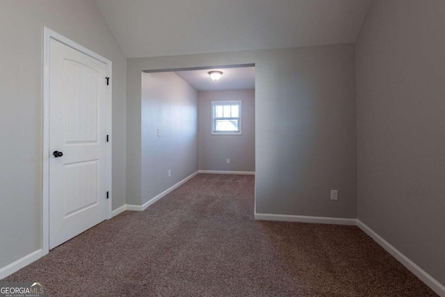 empty room with lofted ceiling and carpet flooring